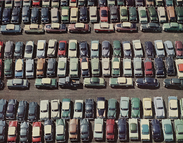 A parking lot with many parked in cars