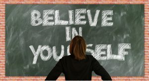 Woman looking at a board that says believe in yourself